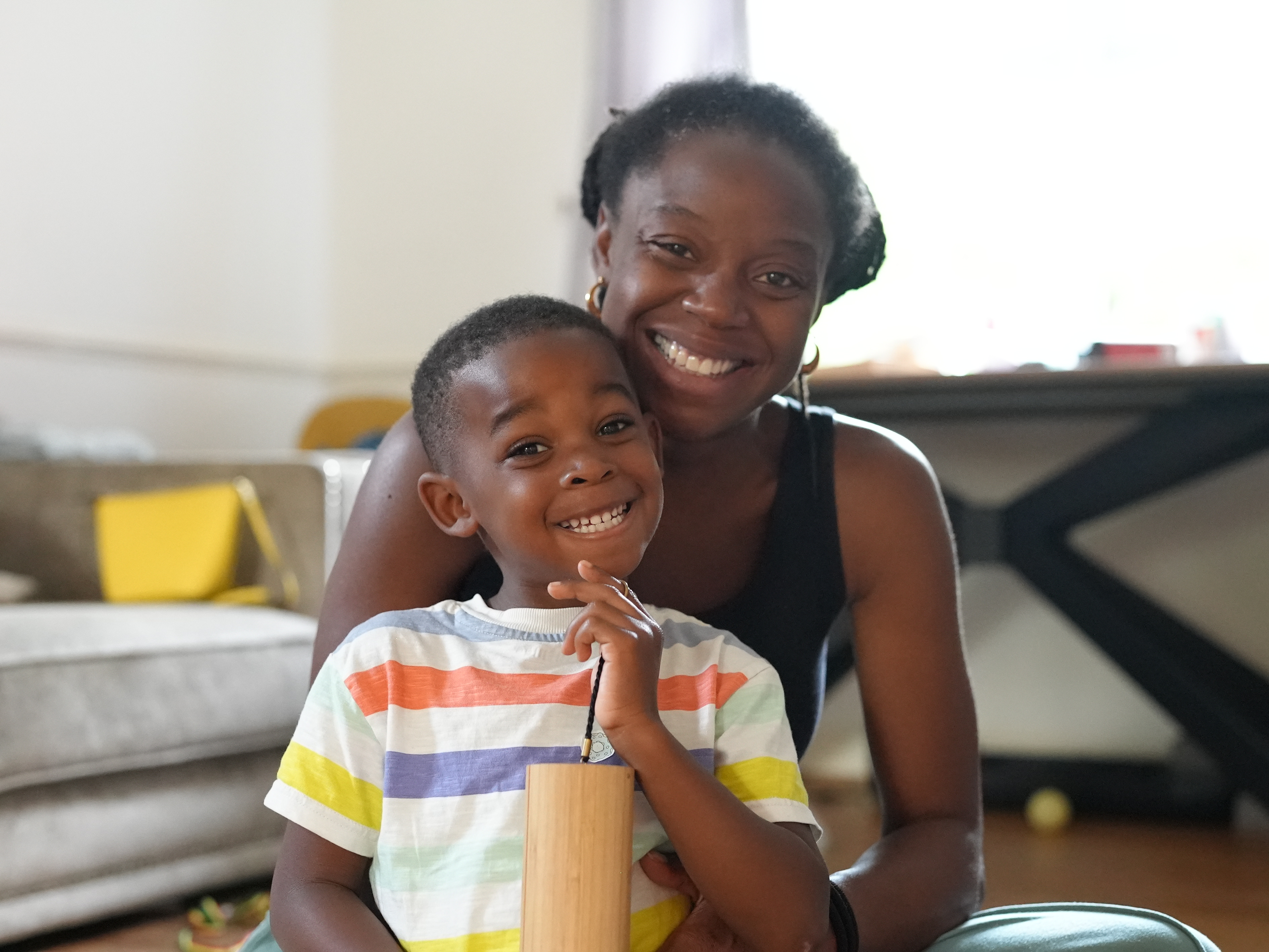 Mother and Son smiling at the camera whilst the son plays a koshi chime